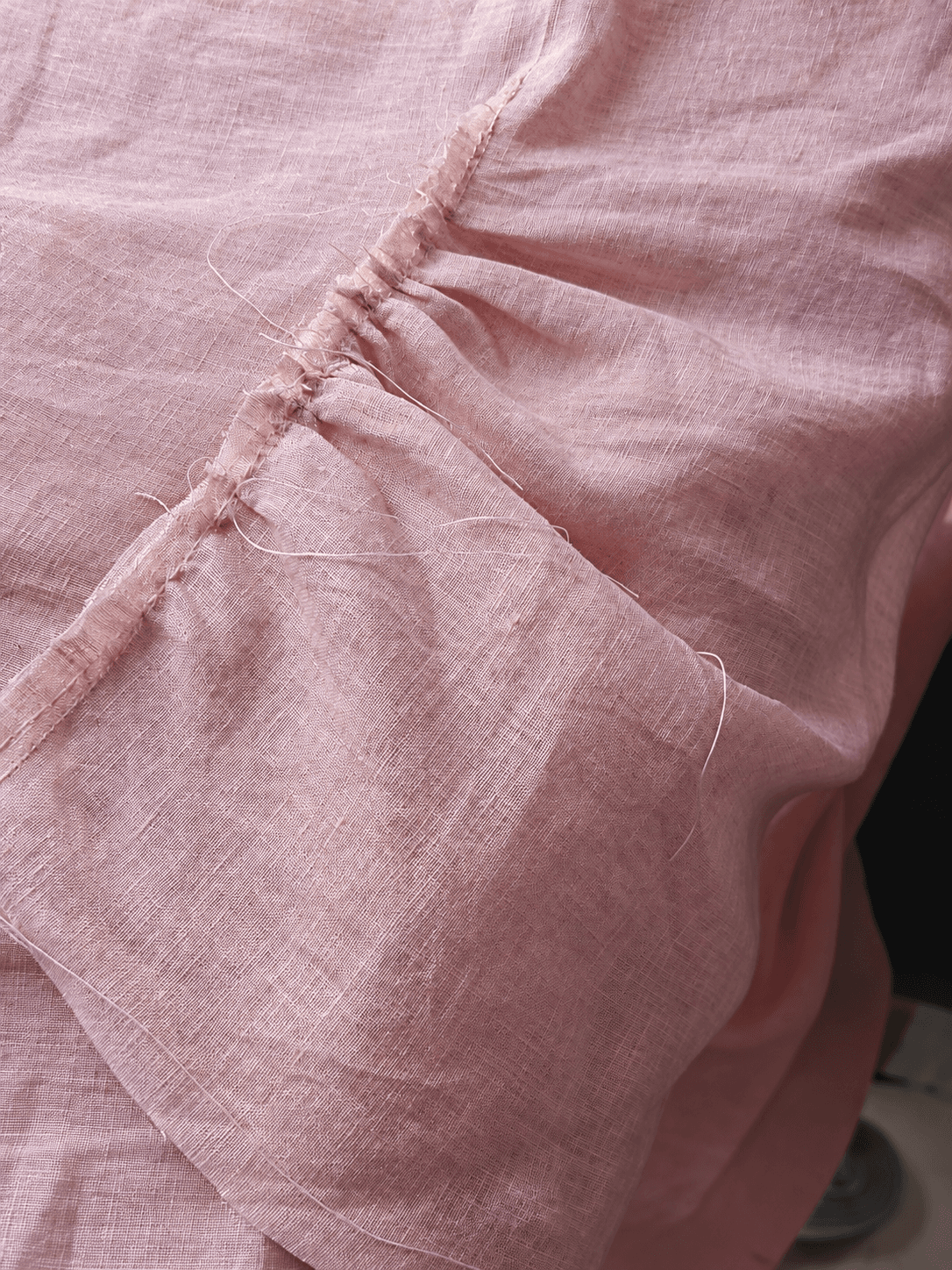Close view of a dusty-rose linen seam under construction